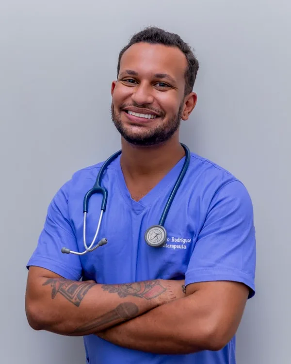 A doctor in scrubs with a stethoscope, arms folded